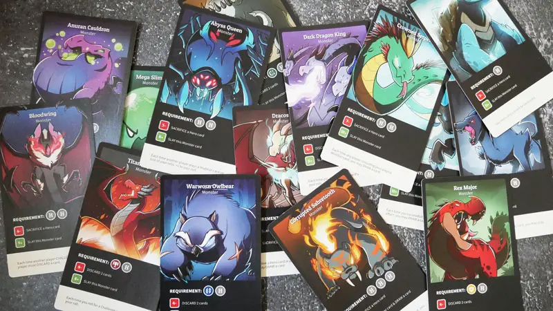 here to slay photo of the monster cards on a grey background