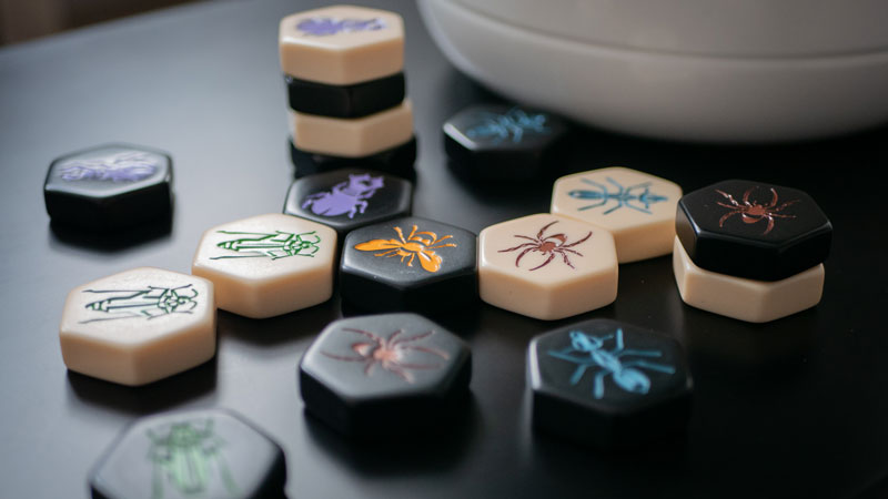 hive board game tiles on a dark table