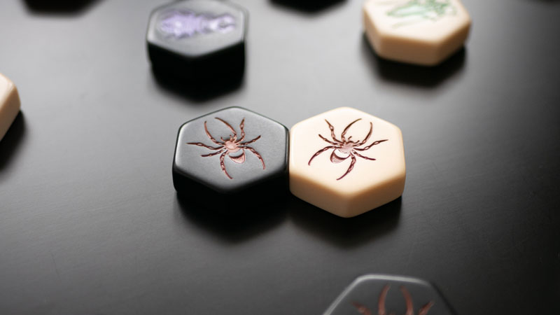 hive board game spider piece on a dark background