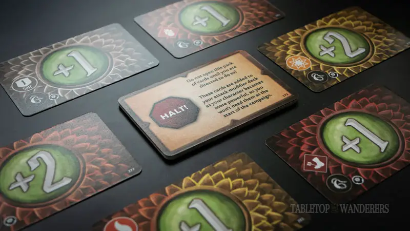 gloomhaven jaws of the lion perks red guard cards on a dark surface